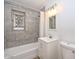 Bathroom with shower and tub combination, a modern vanity, and grey tiled walls at 11223 W Missouri Ave, Youngtown, AZ 85363