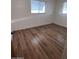 Bedroom with hardwood floors, two bright windows, and neutral wall paint at 11223 W Missouri Ave, Youngtown, AZ 85363