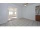 Bright living room boasts white brick walls, ceiling fan, and neutral-colored tile flooring at 11223 W Missouri Ave, Youngtown, AZ 85363