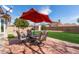 Backyard patio featuring red brick pavers and outdoor furniture under a red patio umbrella at 11445 S 44Th St, Phoenix, AZ 85044