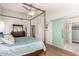 Main bedroom featuring a canopy bed, hardwood floors, and an attached bathroom with glass shower at 11445 S 44Th St, Phoenix, AZ 85044