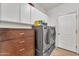 Efficient laundry room with modern appliances and ample storage cabinets for a clutter-free space at 11965 W Monte Vista Rd, Avondale, AZ 85392