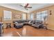 Inviting living room featuring a comfortable sectional sofa, ceiling fan, and natural light from multiple windows at 11965 W Monte Vista Rd, Avondale, AZ 85392