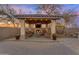 Cozy outdoor living area with a covered patio, a stone fireplace, comfortable seating, and pavers at 11965 W Monte Vista Rd, Avondale, AZ 85392