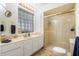 Bathroom featuring a glass block window, double vanity and a gold-trimmed shower at 1309 E Echo Ln, Phoenix, AZ 85020