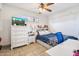 Bright bedroom with a white dresser, desk, and a bed with floral bedding at 1309 E Echo Ln, Phoenix, AZ 85020