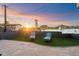 Relaxing backyard with a serene pool, striped lounge chairs, and a beautiful sunset, perfect for enjoying the outdoors at 1309 E Echo Ln, Phoenix, AZ 85020