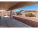 View of the backyard with shed, desert landscaping, brick wall, and covered patio area at 13208 W Desert Rock Dr, Surprise, AZ 85374