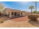 A spacious backyard with desert landscaping, mature palms, and a covered patio, ideal for outdoor living at 13208 W Desert Rock Dr, Surprise, AZ 85374