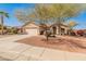 Charming single-story home with a well-manicured front yard and a two-car garage in a residential neighborhood at 13208 W Desert Rock Dr, Surprise, AZ 85374