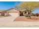 Charming home with desert landscaping, mature tree, and driveway with covered parking at 13208 W Desert Rock Dr, Surprise, AZ 85374