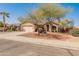 Charming single-story home featuring a well-manicured yard with mature trees and a two-car garage at 13208 W Desert Rock Dr, Surprise, AZ 85374