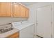 Functional laundry room featuring washer, dryer, sink, ample cabinet storage, and access to the backyard at 13208 W Desert Rock Dr, Surprise, AZ 85374