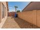 Side yard with a block wall, gravel, and a wooden gate, offering privacy and practicality at 13208 W Desert Rock Dr, Surprise, AZ 85374