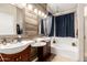 A well-lit bathroom with a double vanity, soaking tub with shower, and wood accent wall provides a relaxing atmosphere at 13232 W Ironwood St, Surprise, AZ 85374