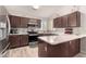 Well-equipped kitchen featuring granite countertops, stainless steel appliances, and dark wood cabinetry at 13232 W Ironwood St, Surprise, AZ 85374