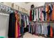 A large walk-in closet with rods and shelves is fully stocked and offers plenty of room for clothing and storage at 13232 W Ironwood St, Surprise, AZ 85374