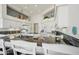 Well-lit kitchen featuring white cabinets, granite countertops, backsplash tiling, and an island with seating at 14110 W Robertson Dr, Sun City West, AZ 85375