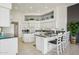 Spacious kitchen featuring white cabinets, granite countertops, tiled floors, and a breakfast bar with seating at 14110 W Robertson Dr, Sun City West, AZ 85375