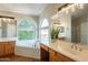 Bright main bathroom featuring double sinks, a large soaking tub, and an abundance of natural light at 1446 E Oxford Ln, Gilbert, AZ 85295