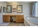 Bathroom features double sinks with vanity, framed mirrors, and separate soaking tub at 15137 W Yucatan Dr, Surprise, AZ 85379