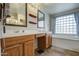 Bright bathroom featuring double sinks, soaking tub, and a large window at 15137 W Yucatan Dr, Surprise, AZ 85379