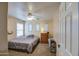 Bright bedroom showcasing a comfortable bed, dresser, ceiling fan, and natural light at 15137 W Yucatan Dr, Surprise, AZ 85379