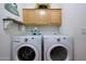 Organized laundry room with a washer, dryer, and upper cabinets for storage at 16546 E Ashbrook Dr # A, Fountain Hills, AZ 85268