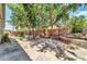 An outdoor seating area on the patio with rock water feature and mature trees creating shaded area in backyard at 17620 W Weatherby Dr, Surprise, AZ 85374