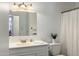 Bathroom featuring a shower with curtain, a toilet, a sink, a large mirror and white cabinetry at 2136 W Sharon Ave, Phoenix, AZ 85029