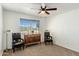 Bedroom with hardwood floors, ceiling fan, large windows, and two chairs at 2136 W Sharon Ave, Phoenix, AZ 85029