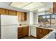 Well-lit kitchen with laminate countertops, wood cabinets, and a white dishwasher at 2136 W Sharon Ave, Phoenix, AZ 85029