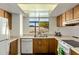 Functional kitchen with laminate countertops, wood cabinetry, and a view of the backyard at 2136 W Sharon Ave, Phoenix, AZ 85029