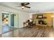 Open living room area with wood floors, fireplace, ceiling fan, sliding glass doors to outdoor pool and an office area at 2136 W Sharon Ave, Phoenix, AZ 85029