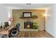 Close up shot of brick fireplace with lit fire, hardwood floors and built in desk at 2136 W Sharon Ave, Phoenix, AZ 85029