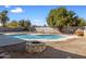 Backyard swimming pool with stone firepit surrounded by mature trees and block wall fencing at 2136 W Sharon Ave, Phoenix, AZ 85029