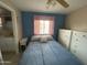 Cozy bedroom with blue accent wall, ceiling fan, and adjacent bathroom at 2315 S Seminole Dr, Apache Junction, AZ 85119