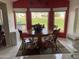 Bright dining room with a wooden table, four chairs, and three large windows offering views of the outdoors at 2315 S Seminole Dr, Apache Junction, AZ 85119