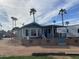 Exterior view of a home featuring a covered patio and palm trees against a bright sky at 2315 S Seminole Dr, Apache Junction, AZ 85119