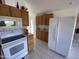 Well-lit kitchen with white appliances, wood cabinetry and vaulted ceiling at 2315 S Seminole Dr, Apache Junction, AZ 85119