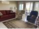 Comfortable living room with a red sofa, sitting chairs and sliding glass doors leading to the outside patio at 2315 S Seminole Dr, Apache Junction, AZ 85119