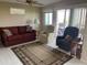 Relaxing living room with a red sofa, sitting chairs, and sliding glass doors leading to the outside patio at 2315 S Seminole Dr, Apache Junction, AZ 85119