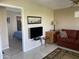 Inviting living room with a comfortable red sofa, TV, and a view into the adjacent bedroom at 2315 S Seminole Dr, Apache Junction, AZ 85119