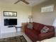 Relaxing living room area with a comfortable red sofa, TV, and a view into the adjacent living space at 2315 S Seminole Dr, Apache Junction, AZ 85119