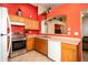 Bright kitchen featuring stainless steel appliances, orange accent wall, and open layout at 23836 W Jefferson St, Buckeye, AZ 85396