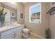 Charming half bathroom with a quartz countertop, white cabinets, modern fixtures, and window at 240 W Missouri Ave # 13, Phoenix, AZ 85013