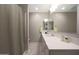 Bathroom featuring a well-lit vanity with double mirrors, modern fixtures, and a shower with grey tile at 240 W Missouri Ave # 13, Phoenix, AZ 85013