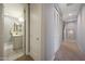 Hallway with access to bathroom featuring a mirrored closet door and view of a bathroom with modern finishes at 240 W Missouri Ave # 13, Phoenix, AZ 85013