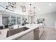 Spacious kitchen island with quartz countertops, stainless steel sink, designer light fixtures, and modern appliances at 240 W Missouri Ave # 13, Phoenix, AZ 85013