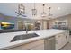 Bright, modern kitchen with an island, stainless steel sink, and open floor plan leading to the living area at 240 W Missouri Ave # 13, Phoenix, AZ 85013